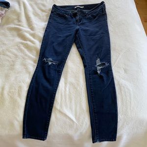 Levi 711 skinny jeans with rips on the knees.